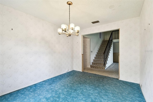 2101 Sunset Point Rd Unit 201, Clearwater, FL 33765 - empty room with a chandelier, stairway, carpet floors, wallpapered walls, and a textured ceiling