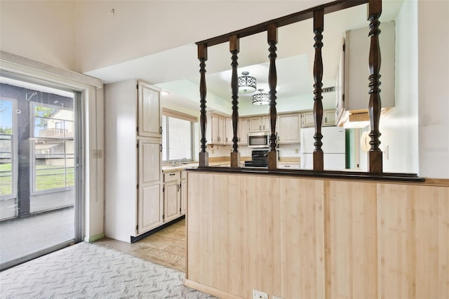 2101 Sunset Point Rd Unit 201, Clearwater, FL 33765 - kitchen featuring freestanding refrigerator, stainless steel microwave, stove, dark countertops, and a peninsula