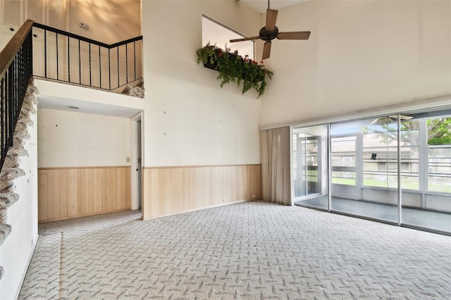 2101 Sunset Point Rd Unit 201, Clearwater, FL 33765 - unfurnished room with a high ceiling, a ceiling fan, a wainscoted wall, carpet flooring, and wood walls