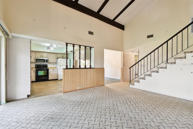 2101 Sunset Point Rd Unit 201, Clearwater, FL 33765 - unfurnished living room featuring high vaulted ceiling, stairs, a chandelier, light colored carpet, and beam ceiling