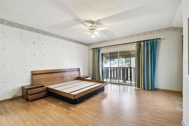 2101 Sunset Point Rd Unit 201, Clearwater, FL 33765 - bedroom featuring wood finished floors, a textured ceiling, access to outside, and a ceiling fan
