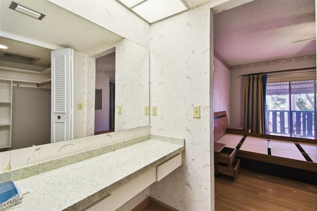 2101 Sunset Point Rd Unit 201, Clearwater, FL 33765 - bathroom featuring wood finished floors, a textured ceiling, and vanity
