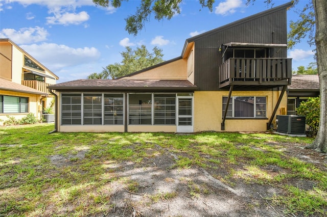 2101 Sunset Point Rd Unit 201, Clearwater, FL 33765 - rear view of property featuring a sunroom, a lawn, and stucco siding