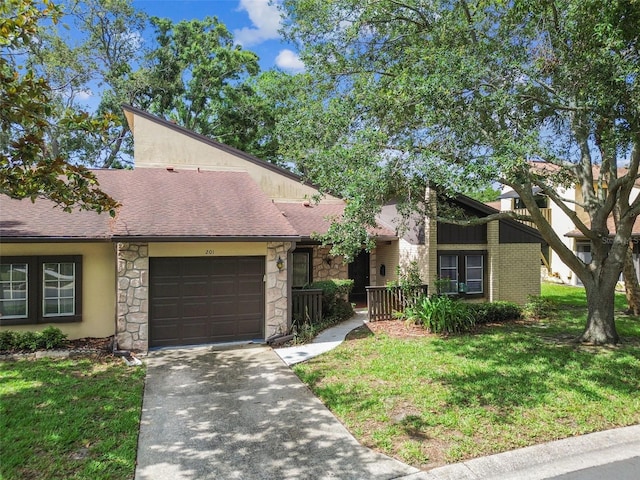 2101 Sunset Point Rd Unit 201, Clearwater, FL 33765 - mid-century inspired home featuring stone siding, an attached garage, concrete driveway, and a shingled roof