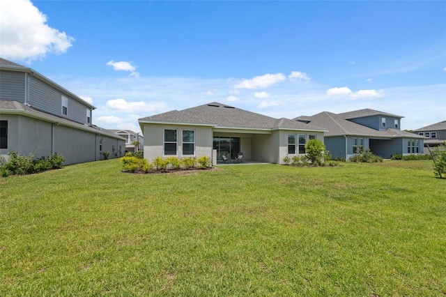33466 Landsman Loop, Wesley Chapel, FL 33543 - back of house featuring stucco siding, a lawn, and roof with shingles