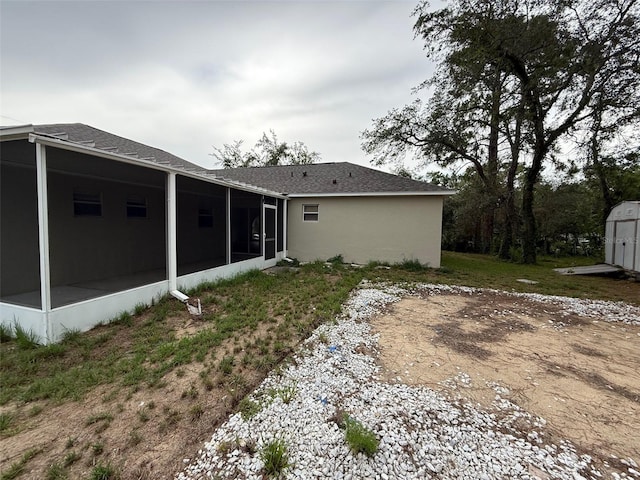 11308 Mahopac Rd, Weeki Wachee, FL 34614 - rear view of property with a sunroom, a storage shed, and a shingled roof