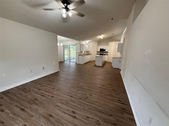 11308 Mahopac Rd, Weeki Wachee, FL 34614 - unfurnished living room with a ceiling fan, lofted ceiling, dark wood-style flooring, and a chandelier