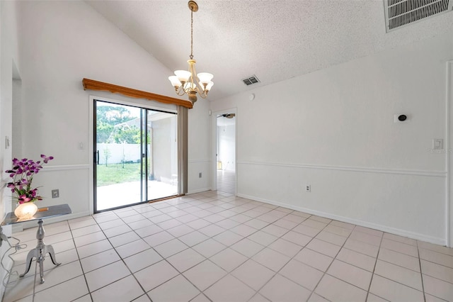 2048 Ground Squirrel Dr, New Port Richey, FL 34655 - spare room with a textured ceiling, a chandelier, vaulted ceiling, and light tile patterned floors
