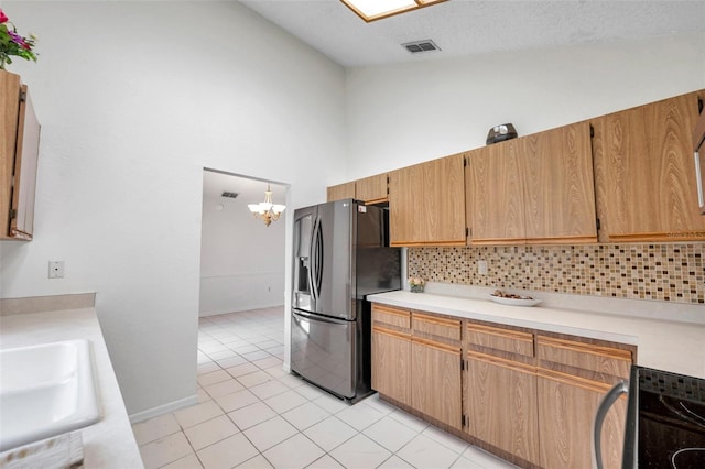 2048 Ground Squirrel Dr, New Port Richey, FL 34655 - kitchen with stainless steel fridge with ice dispenser, tasteful backsplash, light countertops, stove, and high vaulted ceiling