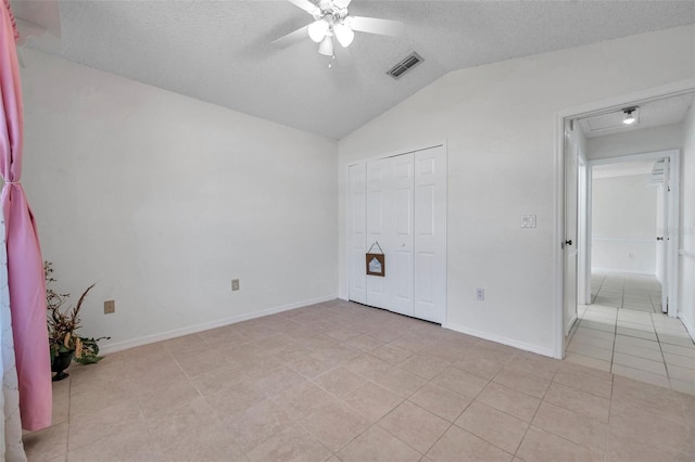 2048 Ground Squirrel Dr, New Port Richey, FL 34655 - unfurnished bedroom with a textured ceiling, lofted ceiling, light tile patterned floors, a closet, and a ceiling fan