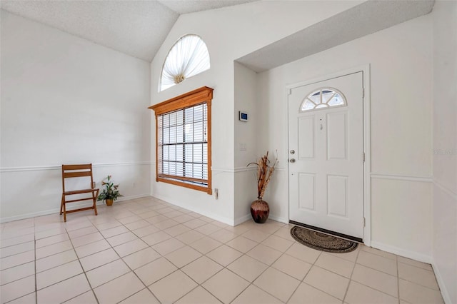 2048 Ground Squirrel Dr, New Port Richey, FL 34655 - entryway featuring plenty of natural light, vaulted ceiling, light tile patterned floors, and a textured ceiling