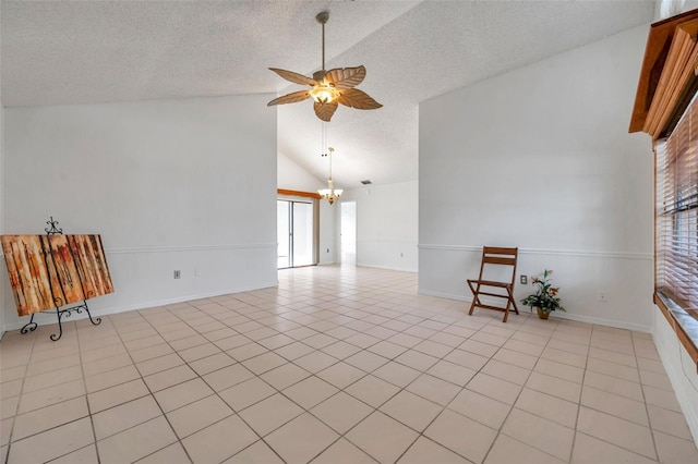 2048 Ground Squirrel Dr, New Port Richey, FL 34655 - spare room featuring a textured ceiling, a ceiling fan, a chandelier, light tile patterned floors, and high vaulted ceiling