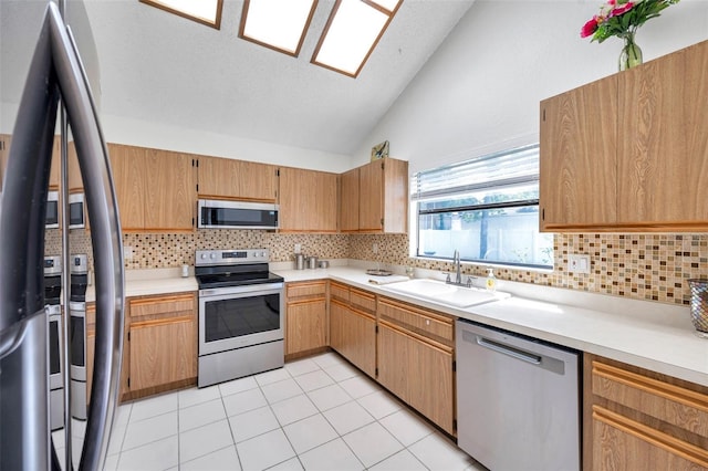 2048 Ground Squirrel Dr, New Port Richey, FL 34655 - kitchen with stainless steel appliances, vaulted ceiling, backsplash, light countertops, and light tile patterned flooring