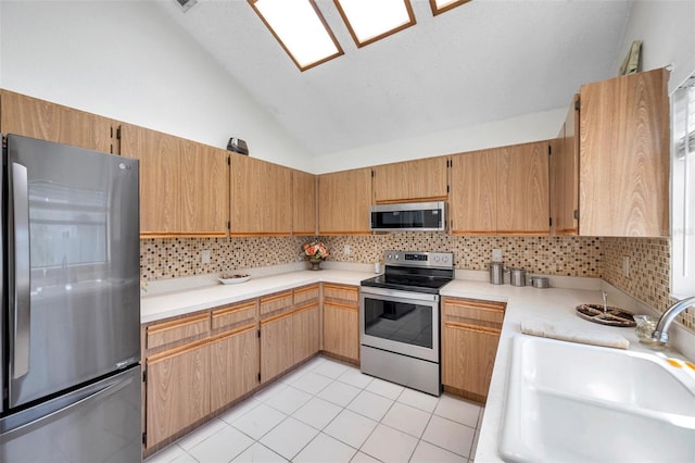 2048 Ground Squirrel Dr, New Port Richey, FL 34655 - kitchen with appliances with stainless steel finishes, vaulted ceiling, backsplash, light countertops, and light tile patterned floors