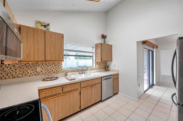 2048 Ground Squirrel Dr, New Port Richey, FL 34655 - kitchen featuring stainless steel appliances, backsplash, light countertops, light tile patterned flooring, and high vaulted ceiling