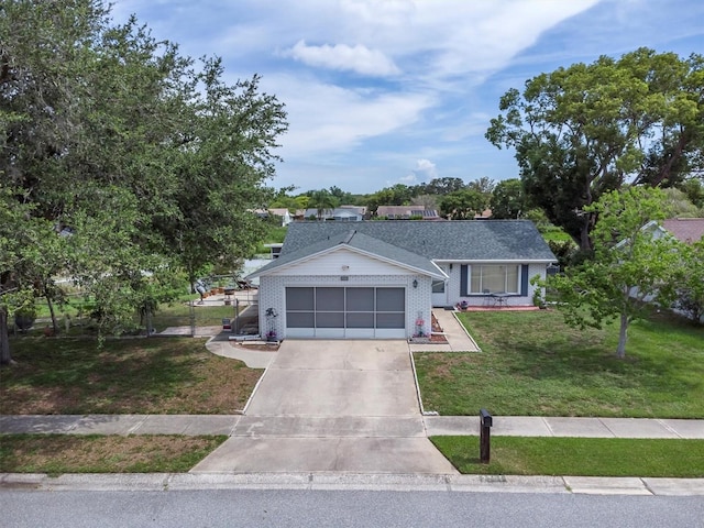 7701 Anaheim Ave, New Port Richey, FL 34655 - view of front of home with concrete driveway, an attached garage, a front yard, and brick siding