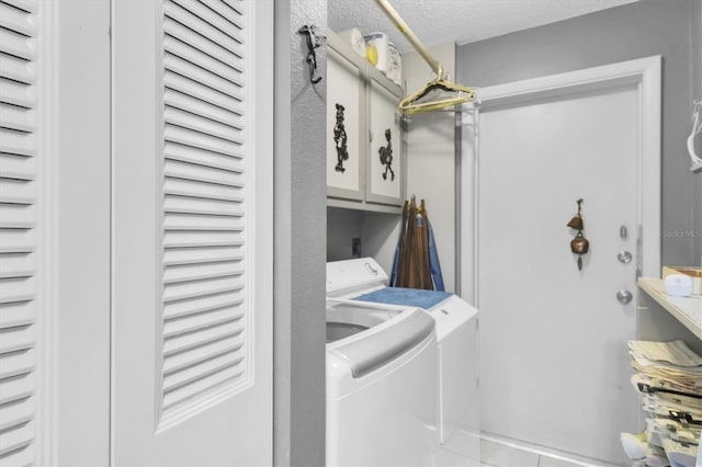7701 Anaheim Ave, New Port Richey, FL 34655 - washroom featuring washer and clothes dryer, cabinet space, and a textured ceiling