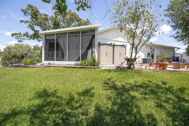 7701 Anaheim Ave, New Port Richey, FL 34655 - rear view of property featuring a sunroom and a storage shed