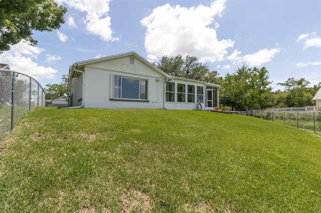 7701 Anaheim Ave, New Port Richey, FL 34655 - back of house featuring a fenced backyard, stucco siding, and a sunroom