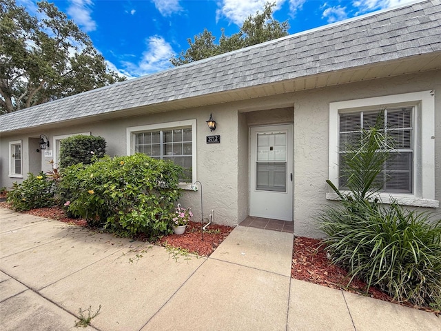3712 Trophy Blvd Unit 3712, New Port Richey, FL 34655 - entrance to property featuring a shingled roof, mansard roof, and stucco siding