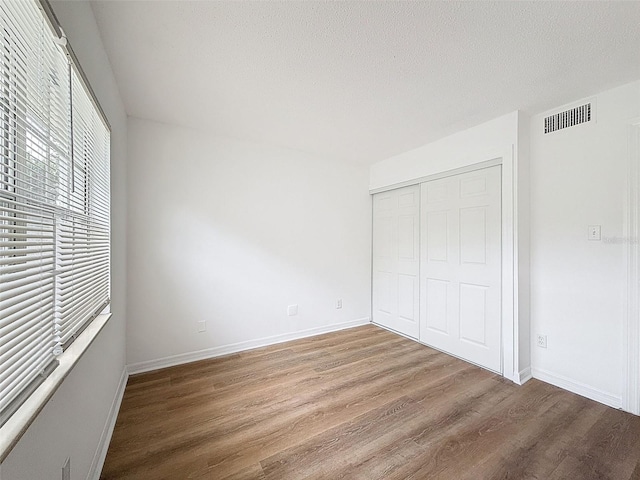 3712 Trophy Blvd Unit 3712, New Port Richey, FL 34655 - unfurnished bedroom with wood finished floors, a closet, and a textured ceiling