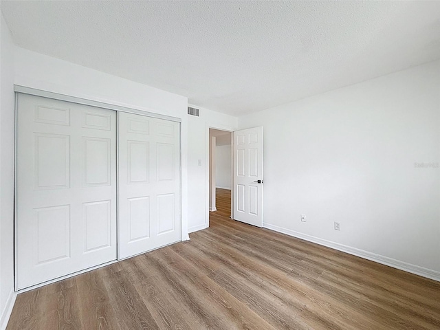 3712 Trophy Blvd Unit 3712, New Port Richey, FL 34655 - unfurnished bedroom with wood finished floors, a closet, and a textured ceiling