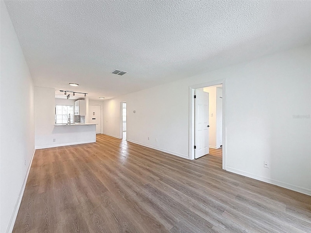 3712 Trophy Blvd Unit 3712, New Port Richey, FL 34655 - unfurnished living room featuring wood finished floors, a textured ceiling, and rail lighting
