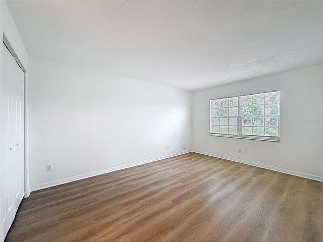 3712 Trophy Blvd Unit 3712, New Port Richey, FL 34655 - unfurnished bedroom featuring wood finished floors, a textured ceiling, and a closet