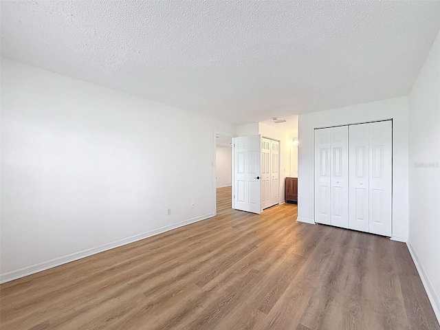 3712 Trophy Blvd Unit 3712, New Port Richey, FL 34655 - unfurnished bedroom featuring light wood-type flooring, a closet, and a textured ceiling