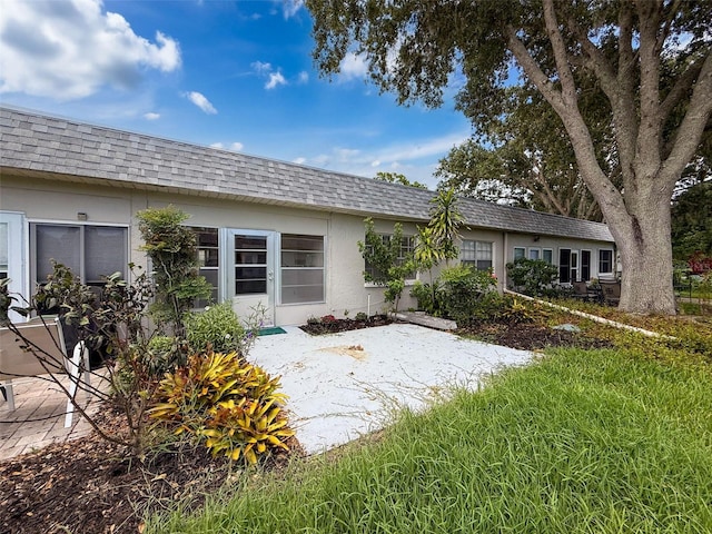 3712 Trophy Blvd Unit 3712, New Port Richey, FL 34655 - back of property with roof with shingles, stucco siding, mansard roof, and a patio