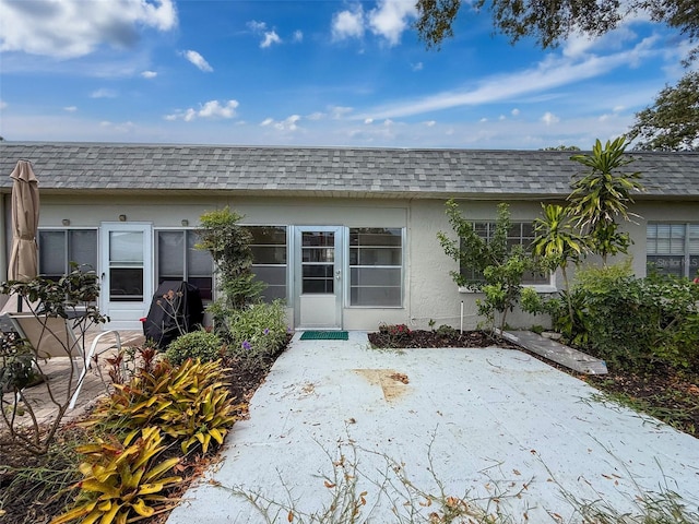 3712 Trophy Blvd Unit 3712, New Port Richey, FL 34655 - back of house with a shingled roof, stucco siding, mansard roof, and a patio area