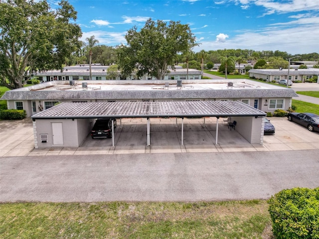 3712 Trophy Blvd Unit 3712, New Port Richey, FL 34655 - rear view of property with covered parking, stucco siding, a metal roof, and a standing seam roof