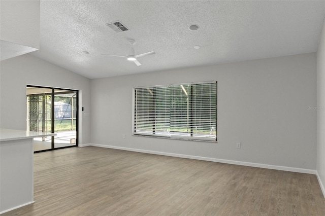 2152 Danforth Rd, Spring Hill, FL 34608 - unfurnished room featuring a textured ceiling, wood finished floors, a ceiling fan, and vaulted ceiling