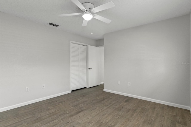 2152 Danforth Rd, Spring Hill, FL 34608 - unfurnished bedroom with dark wood finished floors, a closet, and a ceiling fan