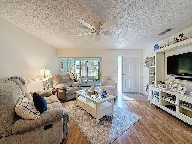 8130 Bugle Ct Unit 3, Port Richey, FL 34668 - living room with a ceiling fan, wood finished floors, and a textured ceiling