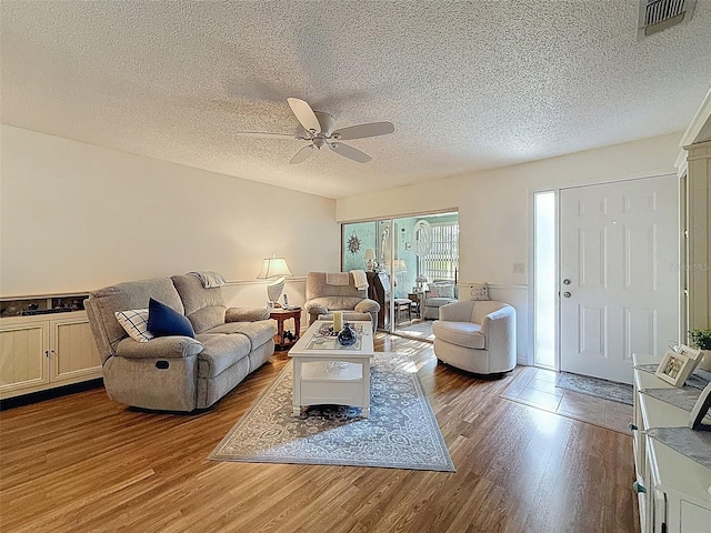 8130 Bugle Ct Unit 3, Port Richey, FL 34668 - living area featuring wood finished floors, a ceiling fan, and a textured ceiling