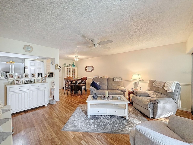 8130 Bugle Ct Unit 3, Port Richey, FL 34668 - living room featuring light wood finished floors, ceiling fan, and a textured ceiling