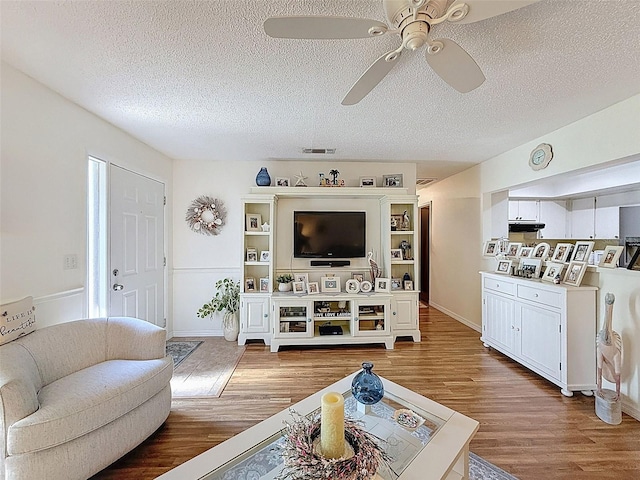 8130 Bugle Ct Unit 3, Port Richey, FL 34668 - living room featuring a ceiling fan, wood finished floors, and a textured ceiling
