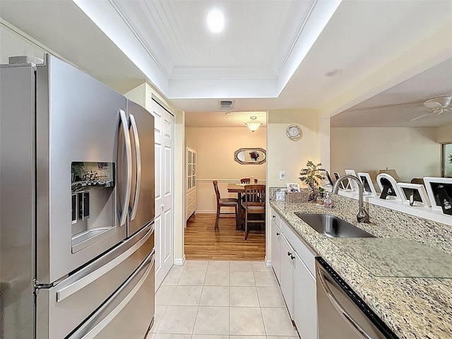 8130 Bugle Ct Unit 3, Port Richey, FL 34668 - kitchen with stainless steel appliances, ornamental molding, a raised ceiling, white cabinets, and light tile patterned flooring