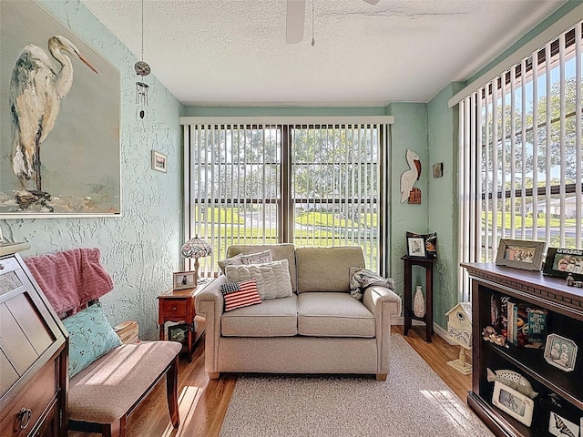 8130 Bugle Ct Unit 3, Port Richey, FL 34668 - living area with plenty of natural light, wood finished floors, ceiling fan, a textured ceiling, and a textured wall