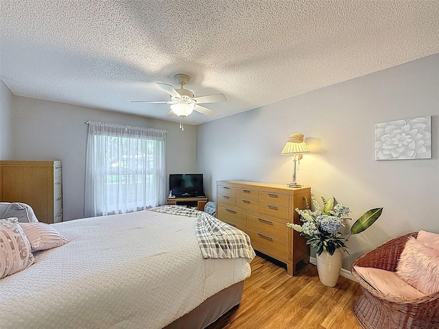 8130 Bugle Ct Unit 3, Port Richey, FL 34668 - bedroom with light wood-style floors, ceiling fan, and a textured ceiling