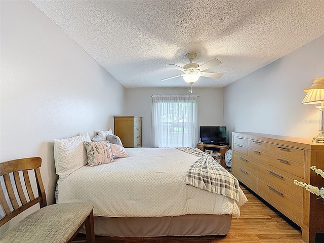 8130 Bugle Ct Unit 3, Port Richey, FL 34668 - bedroom with light wood-style floors, a textured ceiling, and ceiling fan