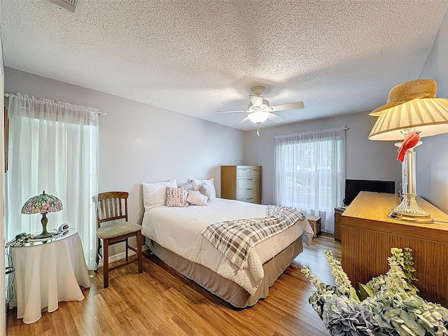 8130 Bugle Ct Unit 3, Port Richey, FL 34668 - bedroom featuring wood finished floors, a textured ceiling, and ceiling fan