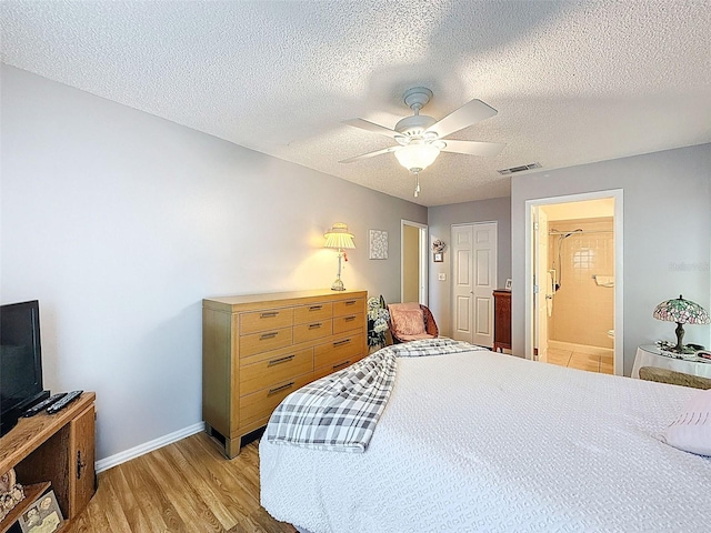 8130 Bugle Ct Unit 3, Port Richey, FL 34668 - bedroom featuring light wood-style floors, a textured ceiling, ensuite bath, and a ceiling fan