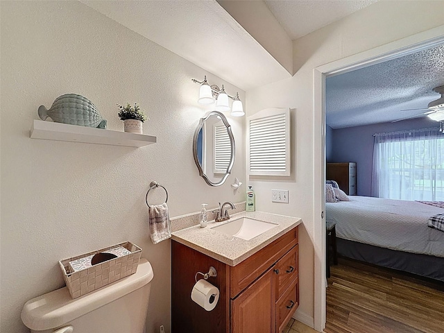 8130 Bugle Ct Unit 3, Port Richey, FL 34668 - ensuite bathroom featuring vanity, wood finished floors, a textured ceiling, and ceiling fan