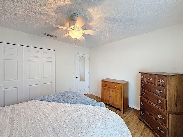 8130 Bugle Ct Unit 3, Port Richey, FL 34668 - bedroom with light wood-style flooring, a textured ceiling, a closet, and a ceiling fan