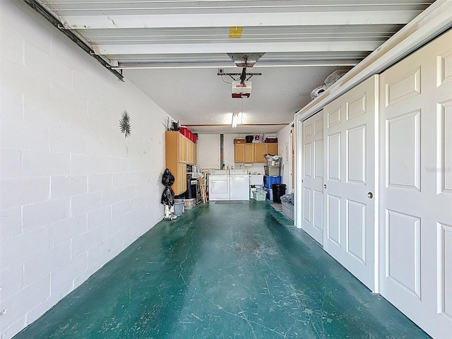8130 Bugle Ct Unit 3, Port Richey, FL 34668 - garage with washer and clothes dryer, concrete block wall, and a garage door opener