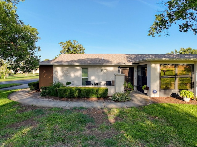 8130 Bugle Ct Unit 3, Port Richey, FL 34668 - rear view of property featuring stucco siding and a lawn