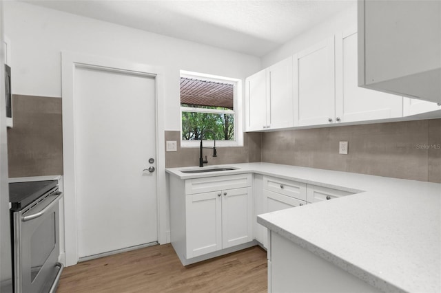 7192 Catalina St, Spring Hill, FL 34606 - kitchen with stainless steel electric range oven, light countertops, light wood-type flooring, and white cabinets