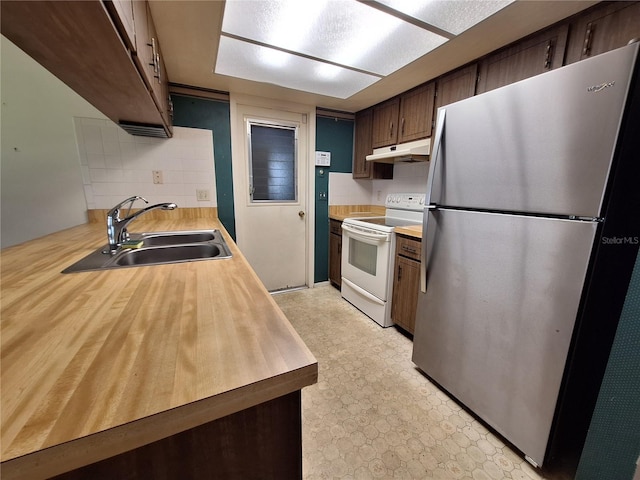 4420 Sawgrass Blvd, New Port Richey, FL 34653 - kitchen featuring freestanding refrigerator, white electric range oven, under cabinet range hood, decorative backsplash, and light flooring